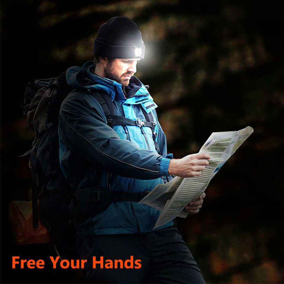 covek cita novine u mraku sa kapom lampom